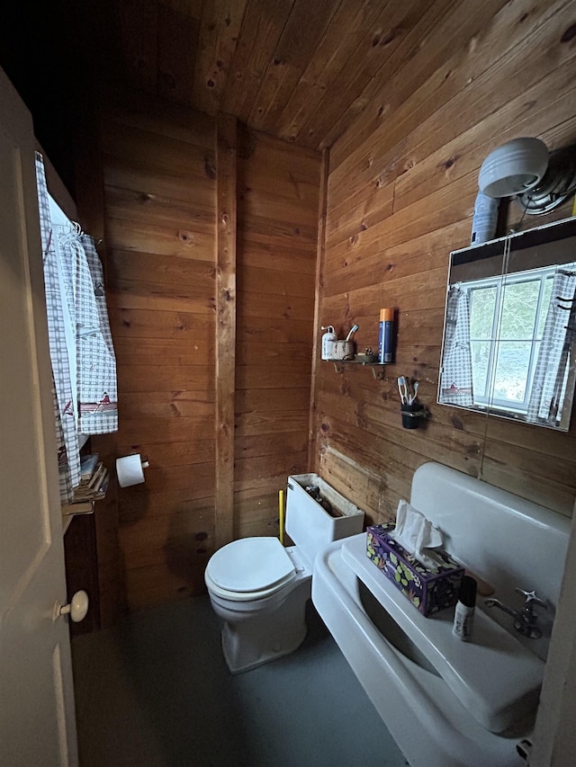 half bathroom with wooden walls, toilet, and wooden ceiling