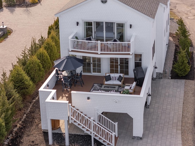 rear view of house with an outdoor hangout area, outdoor dining area, and a balcony