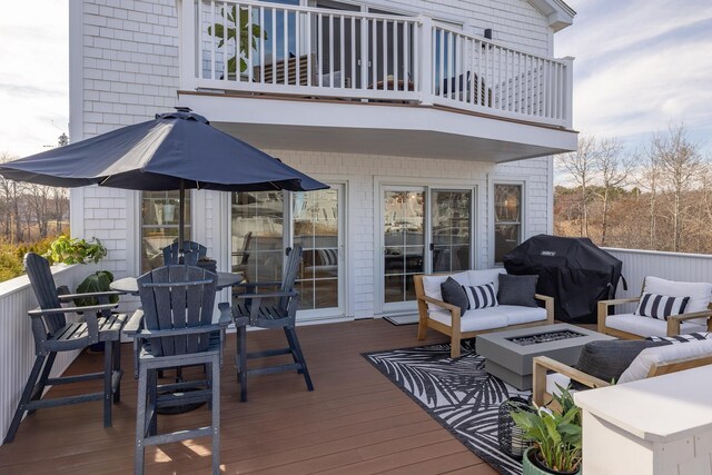 deck featuring outdoor dining space, a grill, and an outdoor living space with a fire pit