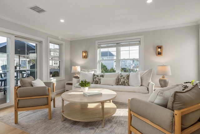 sitting room with ornamental molding, visible vents, and plenty of natural light
