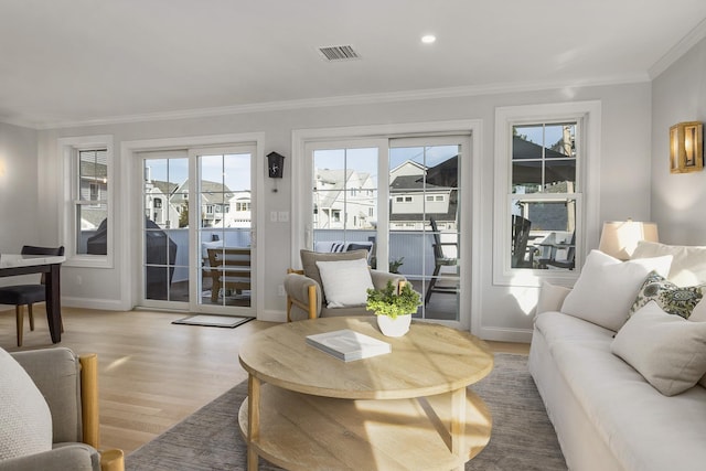 living area with crown molding, light wood-style flooring, visible vents, recessed lighting, and baseboards