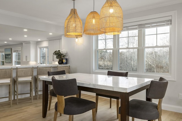 dining space with recessed lighting, light wood finished floors, baseboards, and ornamental molding