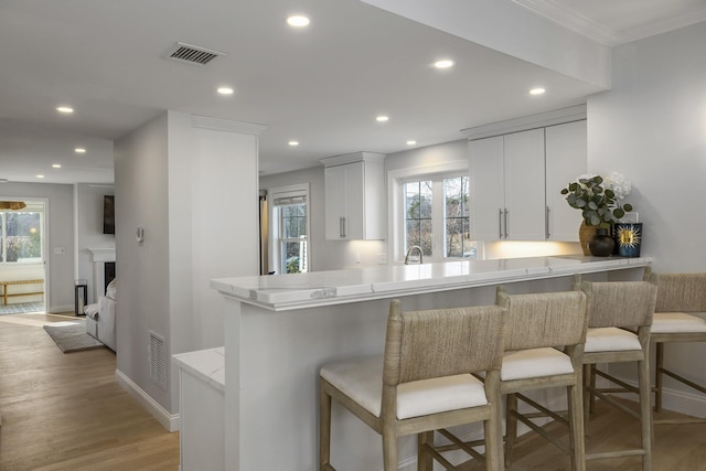 kitchen with a breakfast bar, visible vents, and recessed lighting