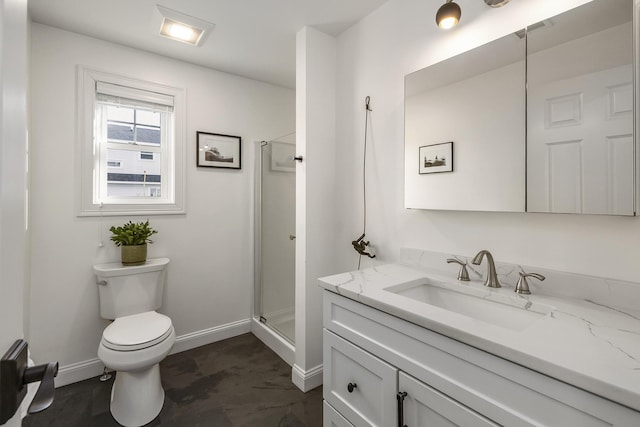 bathroom featuring toilet, a stall shower, vanity, and baseboards