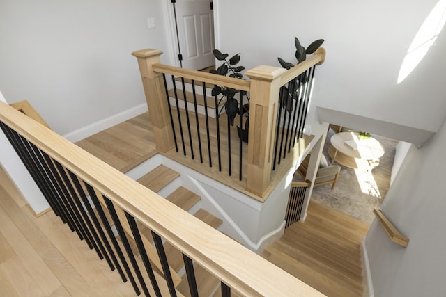 staircase featuring baseboards and wood finished floors