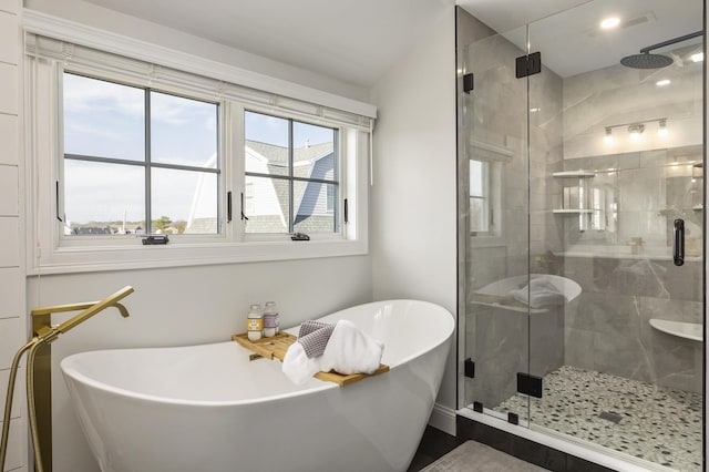 bathroom featuring a shower stall and a soaking tub