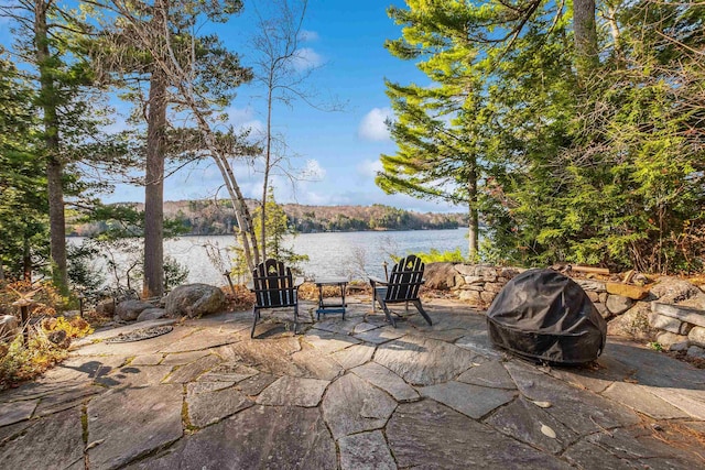view of patio / terrace featuring a water view, a fire pit, and grilling area