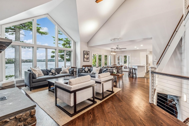 living room featuring high vaulted ceiling, a wealth of natural light, a water view, and dark wood finished floors