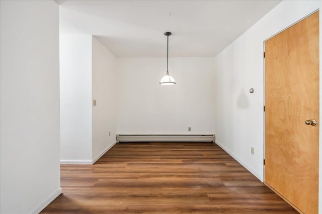 unfurnished dining area with baseboards, baseboard heating, and wood finished floors