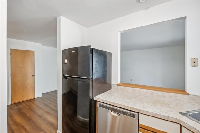 kitchen with dishwasher, dark wood-type flooring, light countertops, and freestanding refrigerator