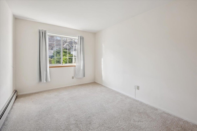 carpeted spare room with a baseboard radiator and baseboards