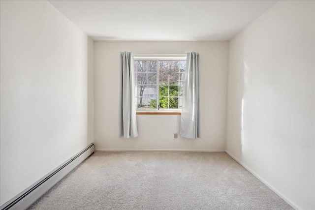 carpeted spare room featuring baseboards and a baseboard radiator