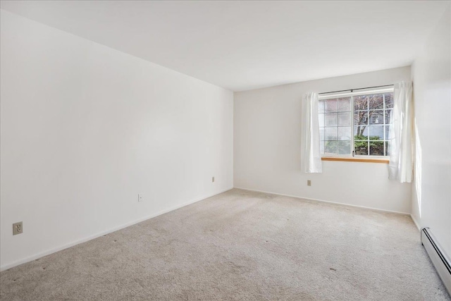 spare room featuring a baseboard radiator, carpet floors, and baseboards