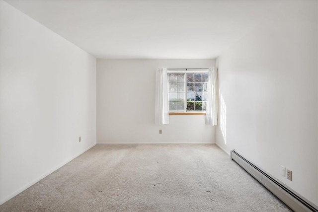spare room with a baseboard radiator, carpet floors, and baseboards