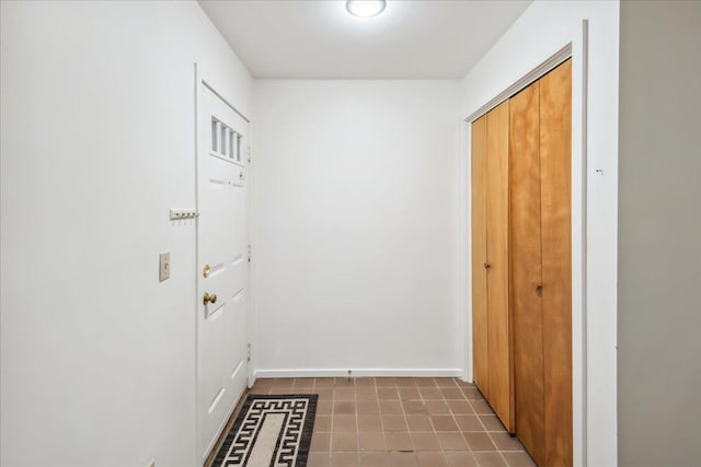 entryway with baseboards and tile patterned flooring
