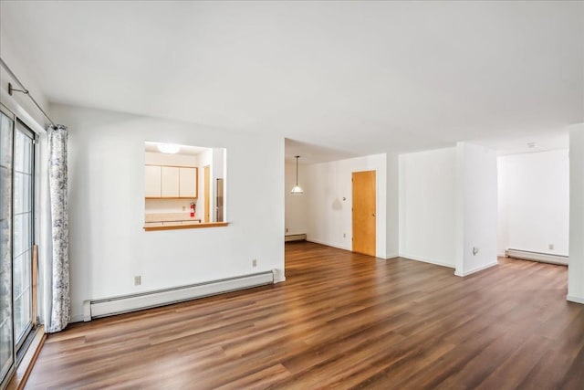 unfurnished living room featuring baseboard heating, baseboards, and wood finished floors