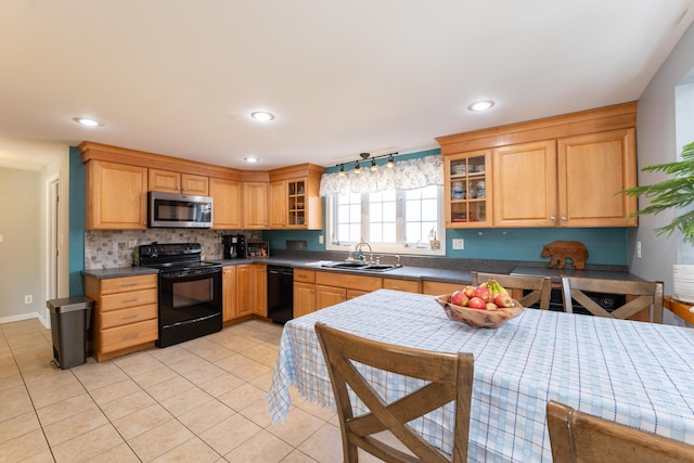 kitchen with black appliances, a sink, light tile patterned floors, glass insert cabinets, and recessed lighting