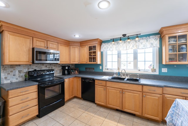 kitchen with black appliances, a sink, light tile patterned flooring, dark countertops, and glass insert cabinets