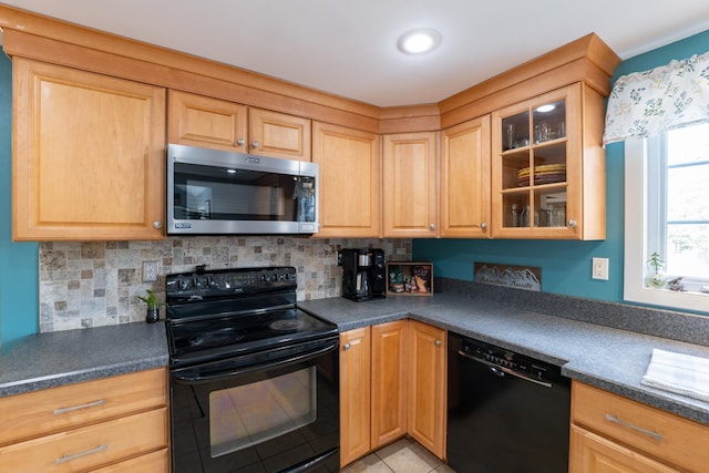 kitchen with black appliances, light tile patterned floors, dark countertops, and decorative backsplash