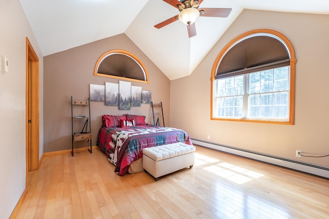 bedroom featuring hardwood / wood-style floors, lofted ceiling, a baseboard heating unit, ceiling fan, and baseboards