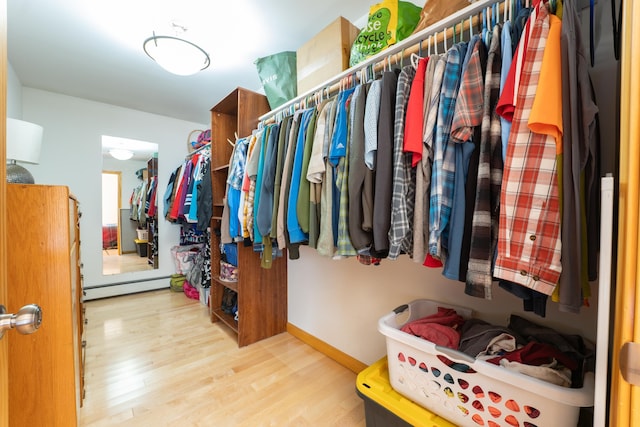walk in closet featuring baseboard heating and wood finished floors