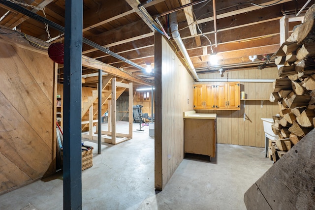 unfinished basement featuring wood walls