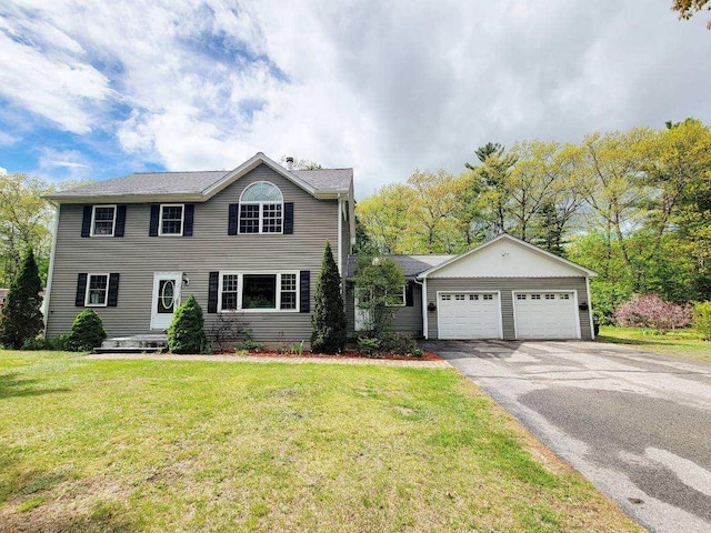 colonial-style house with asphalt driveway, a front yard, and a garage