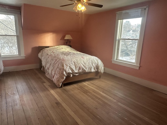 bedroom featuring wood-type flooring, baseboards, and ceiling fan