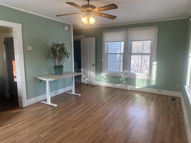 interior space with ceiling fan, baseboards, crown molding, and visible vents