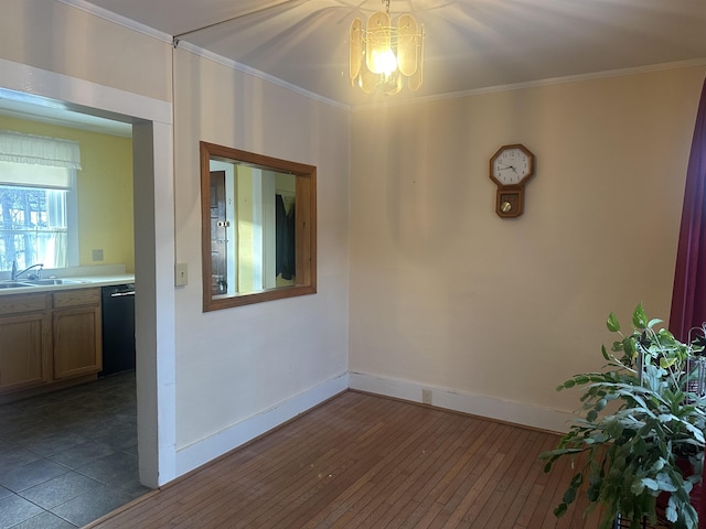 spare room with crown molding, a sink, a chandelier, baseboards, and dark wood-style flooring