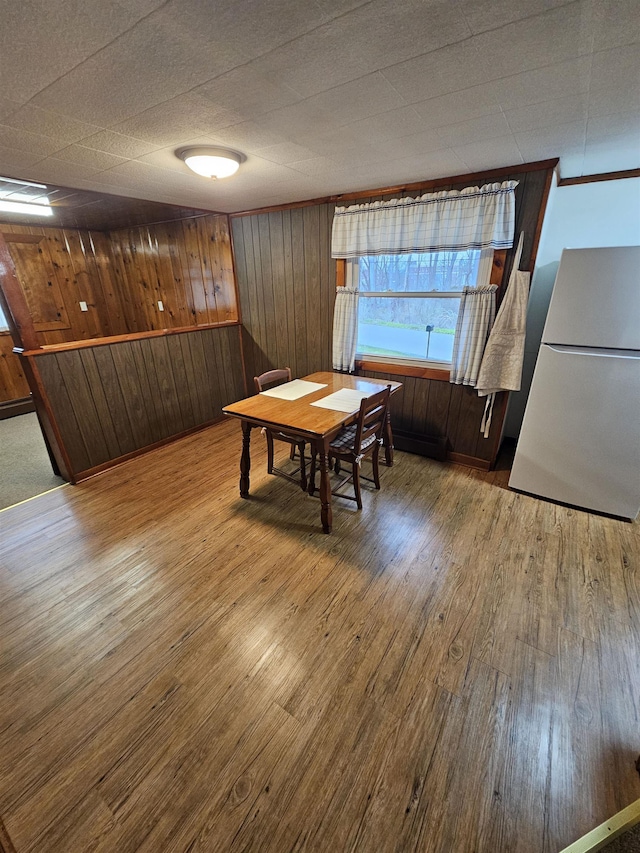 dining area featuring wooden walls and wood finished floors