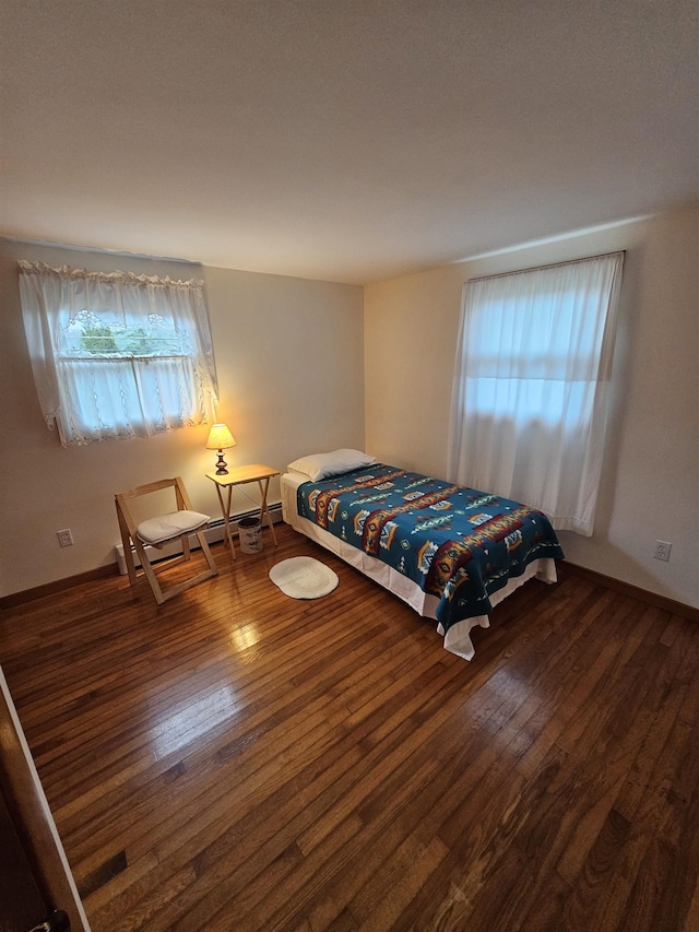 bedroom featuring wood finished floors and multiple windows