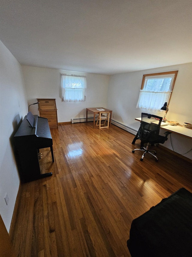 office with a baseboard heating unit and wood finished floors