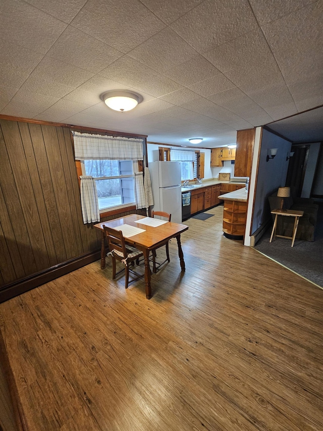 dining room featuring wooden walls and wood finished floors