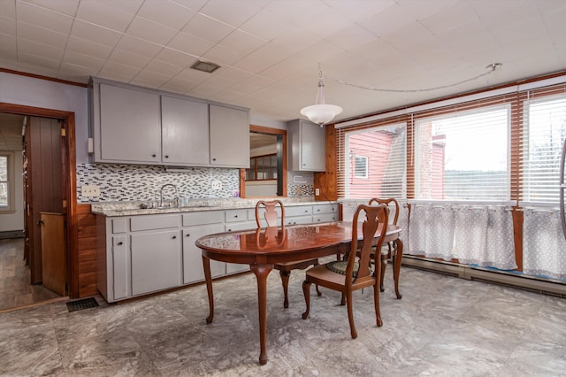 dining room with baseboard heating, visible vents, and a healthy amount of sunlight