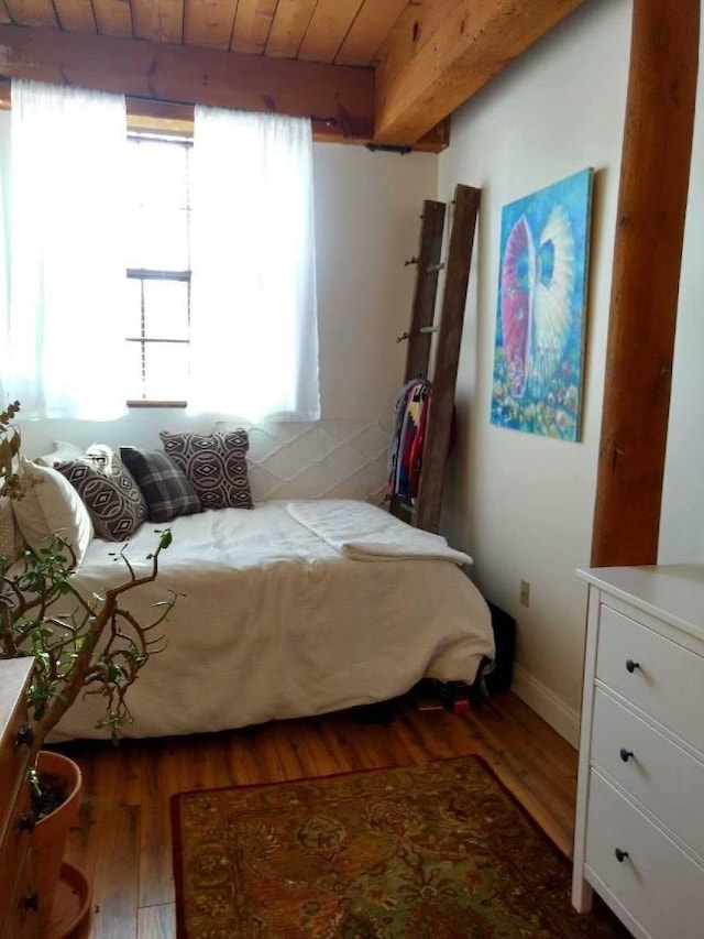 bedroom with wood finished floors, beamed ceiling, baseboards, and wooden ceiling