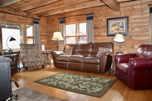 living room featuring beamed ceiling, wood-type flooring, and a healthy amount of sunlight