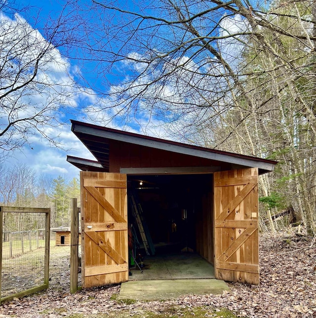 view of outdoor structure featuring fence and an outdoor structure