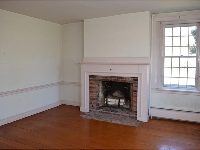 1419 Stonebridge Rd, Georgia, VT 05468 - unfurnished living room with wood finished floors, a brick fireplace, baseboard heating, and plenty of natural light