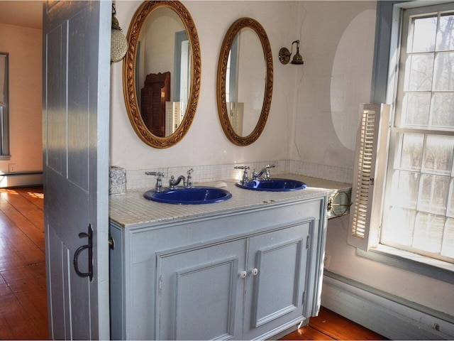 1419 Stonebridge Rd, Georgia, VT 05468 - bathroom featuring baseboard heating, wood finished floors, a sink, and double vanity