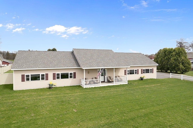 back of property with fence, a lawn, and a patio area
