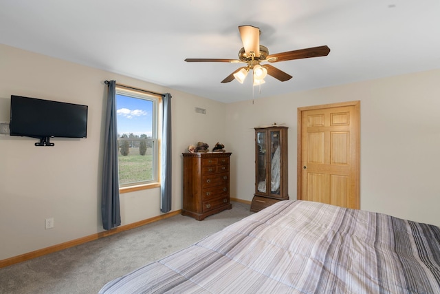 bedroom with baseboards, visible vents, light colored carpet, and ceiling fan