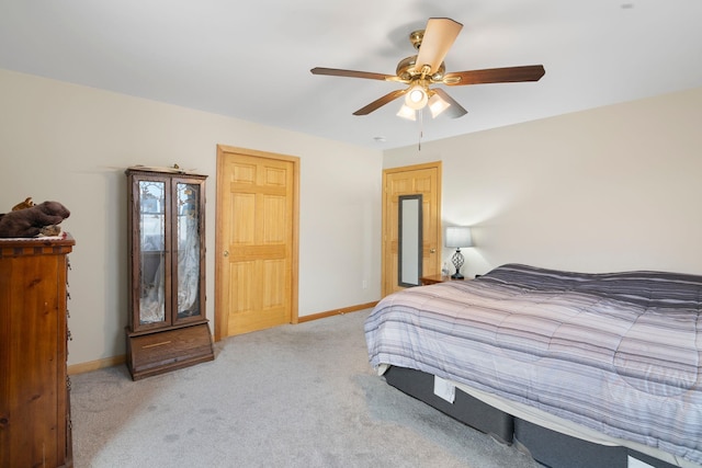 bedroom featuring baseboards, light colored carpet, and ceiling fan