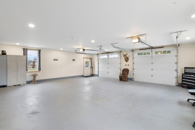 garage featuring baseboards, a garage door opener, and recessed lighting