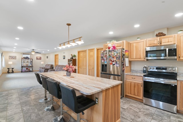 kitchen featuring recessed lighting, open floor plan, stainless steel appliances, and a kitchen island