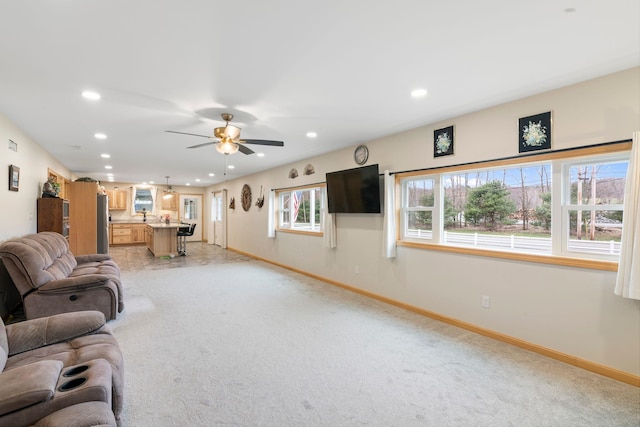unfurnished living room with recessed lighting, baseboards, and light carpet