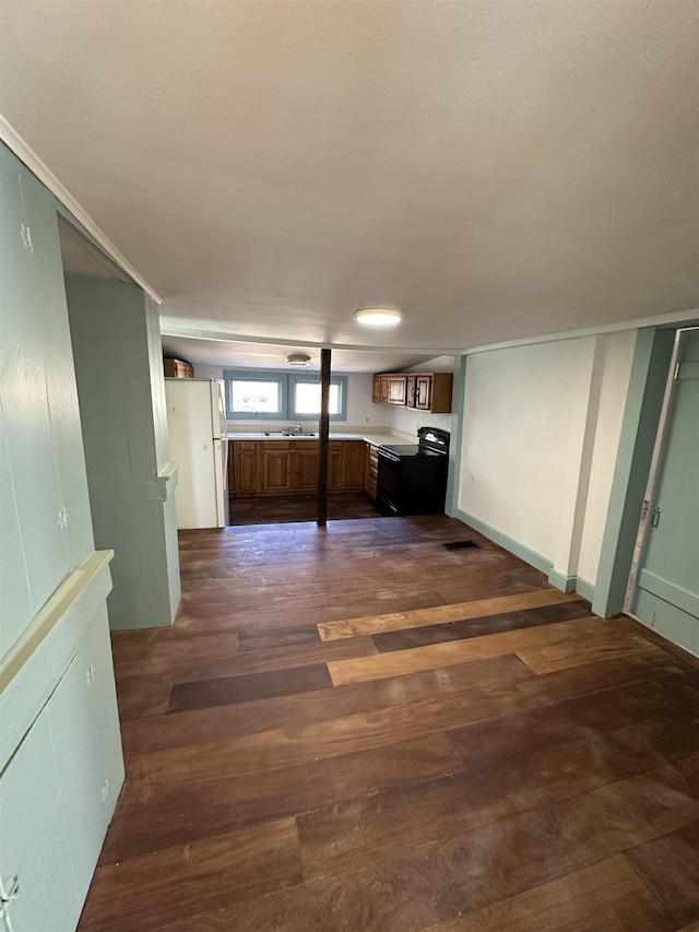 unfurnished living room featuring dark wood finished floors and a sink