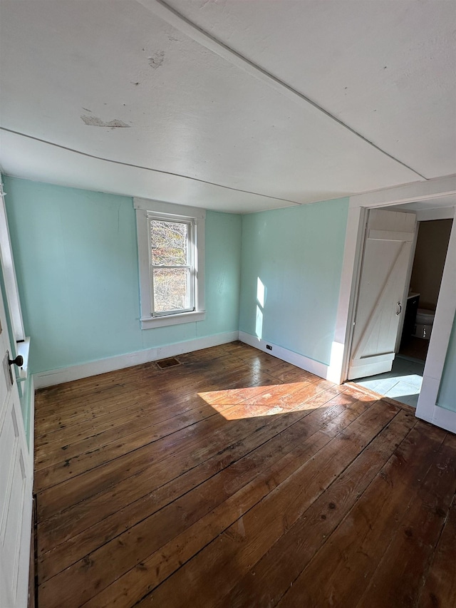 unfurnished room with hardwood / wood-style flooring and baseboards