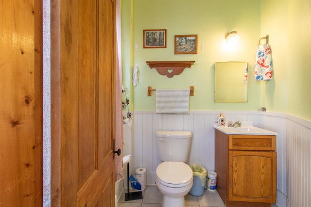 bathroom featuring wainscoting, toilet, vanity, and tile patterned floors