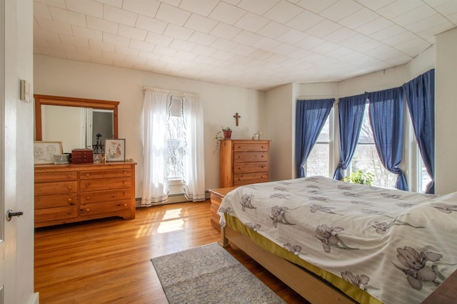 bedroom with light wood-type flooring and multiple windows